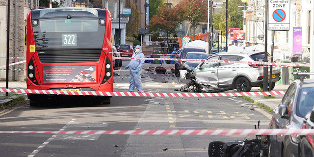 Police officers in forensic suits at the scene on Railton Road in Lambeth, where two men have died after gunshots were heard on Sunday evening, in South London, Monday, Oct. 31, 2022.