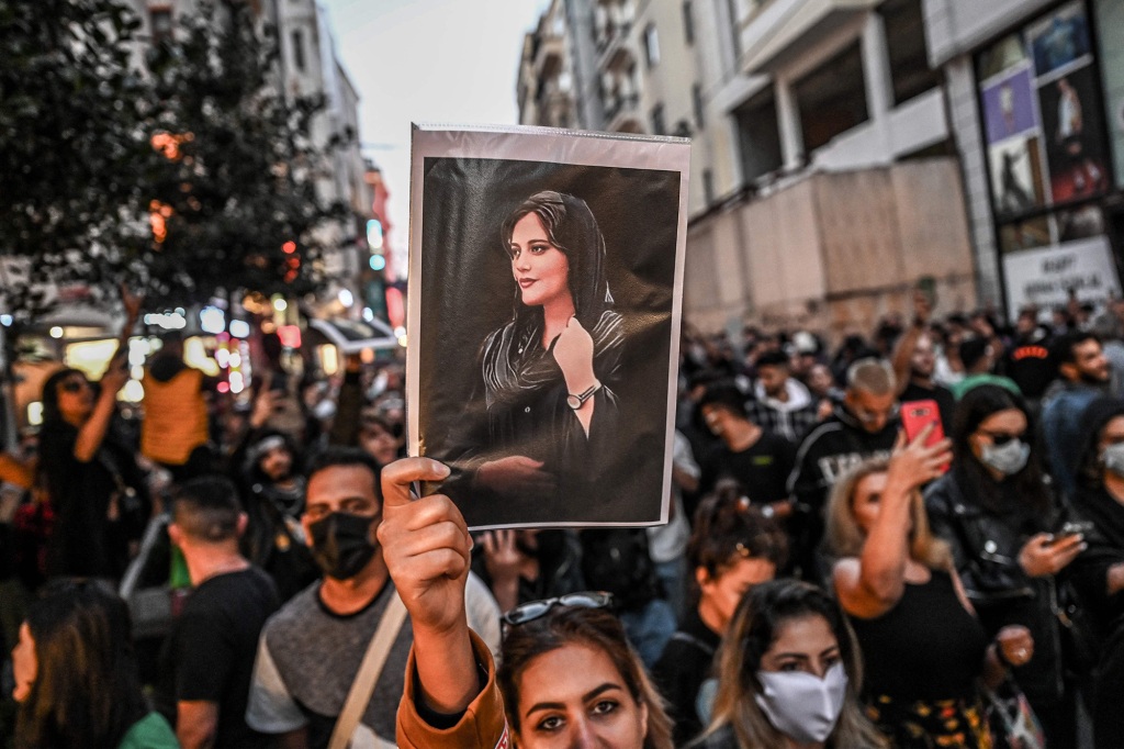 A protester holds a portrait of Mahsa Amini during a march in Istanbul on Sept. 20, 2022.