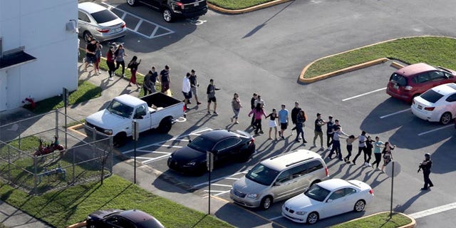 Students are evacuated by police from Marjory Stoneman Douglas High School in Parkland, Fla., during the shooting that took place there in February.