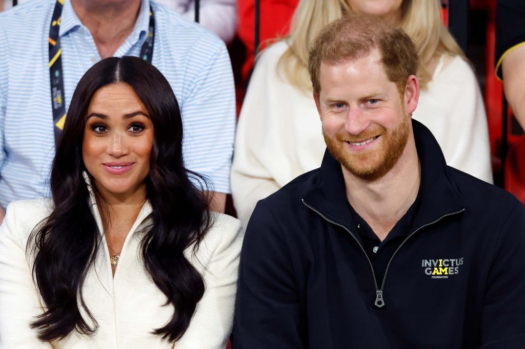 Meghan Markle with Prince Harry sitting in a crowd. 