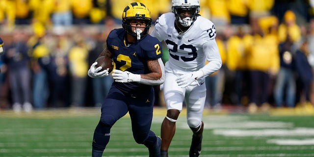 Michigan running back Blake Corum (2) runs the ball as Penn State linebacker Curtis Jacobs (23) chases in the first half of an NCAA college football game in Ann Arbor, Mich., Saturday, Oct. 15, 2022.