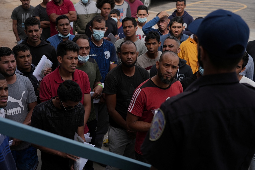 A picture of migrants being greeted and given a briefing by shelter staff in El Paso, Texas. 