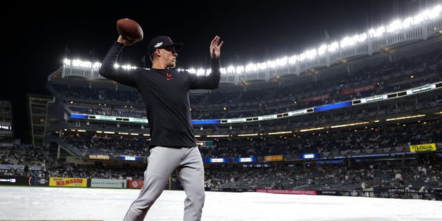 Myles Straw #7 of the Cleveland Guardians tosses a football to fans in the stands prior to playing the New York Yankees in game five of the American League Division Series at Yankee Stadium on October 17, 2022 in New York, New York.