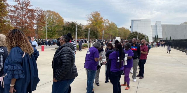 Supports wait in line to pass through security to attend a rally with former President Barack Obama, Democratic Sen. Raphael Warnock of Georgia, and Democratic gubernatorial nominee Stacey Abrams, on Oct. 28, 2022 in College Park, Georgia