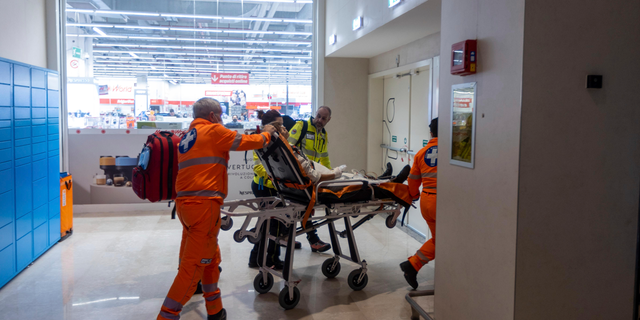 Emergency personnel wheel an injured person at the scene of an attack in Milan, Italy, Thursday Oct. 27, 2022. 