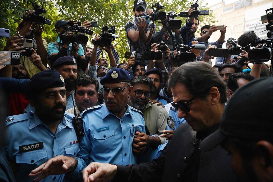 A picture of Pakistan's former Prime Minister Imran Khan surrounded by police and media.