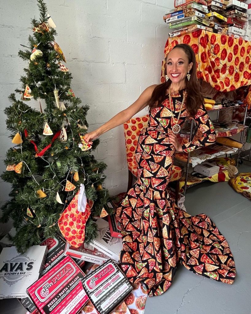 A picture of Cuppari in a pizza dress next to a Christmas tree adorned with pizza ornaments. 