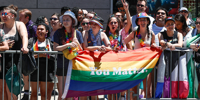 People hold a rainbow flag during the 51st LGBTQ Pride Parade in Chicago, Illinois, on June 26, 2022. - The Pride Parade returned to the Lakeview and Uptown neighborhoods after a three-year hiatus due to the coronavirus pandemic. 