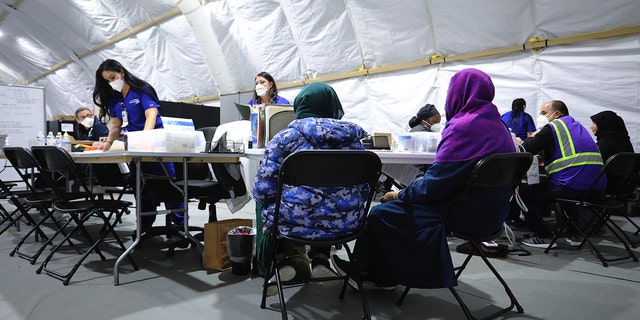 Afghan refugee women register to be seen by a doctor inside the medical tent at Liberty Village on Joint Base McGuire-Dix- Lakehurst, N.J., on Dec, 2, 2021. 