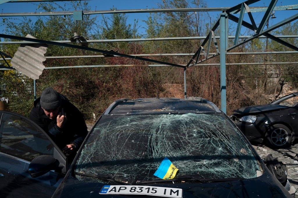 Dmytro Pocishchuk checks his car, which was damaged after a Russian attack in Zaporizhzhia.