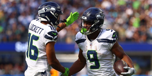 Tyler Lockett #16 of the Seattle Seahawks celebrates with Kenneth Walker III #9 after a touchdown during the first quarter of the game against the Los Angeles Chargers at SoFi Stadium on October 23, 2022, in Inglewood, California. 