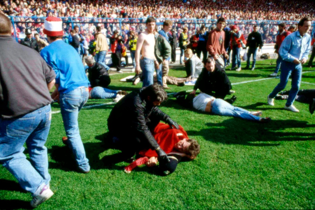 People tend and care for wounded supporters on the field at Hillsborough Stadium, in Sheffield, England, April 15, 1989.