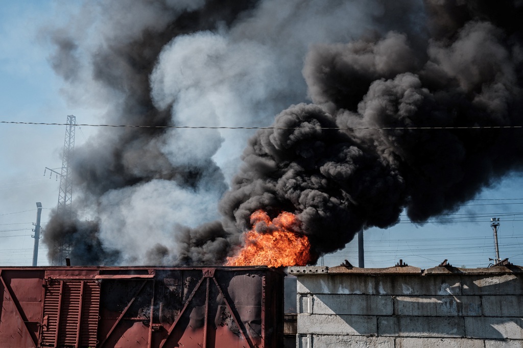 A car and piled sleepers are burning after a shelling near the Lyman station in Lyman, eastern Ukraine.