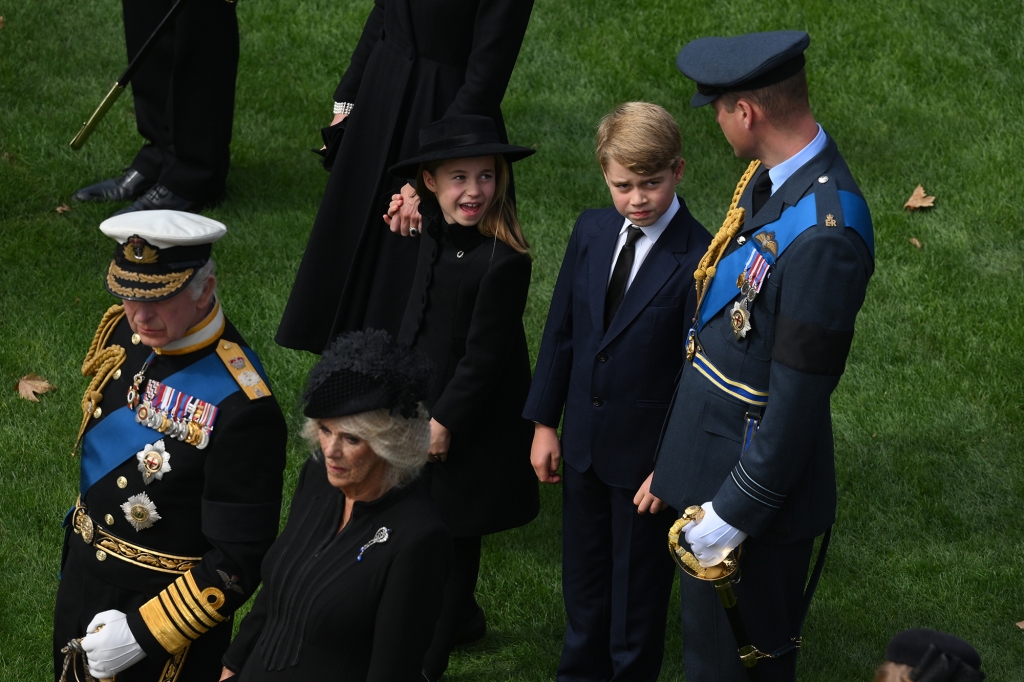 LONDON, ENGLAND - SEPTEMBER 19: King Charles III (L), Camilla, Queen Consort, Catherine, Princess of Wales, Princess Charlotte of Wales, Prince George of Wales and Prince William, Prince of Wales, watch the Bearer Party transfer the coffin of Queen Elizabeth II, draped in the Royal Standard, into the State Hearse at Wellington Arch following the State Funeral of Queen Elizabeth II at Westminster Abbey on September 19, 2022 in London, England.  Elizabeth Alexandra Mary Windsor was born in Bruton Street, Mayfair, London on 21 April 1926. She married Prince Philip in 1947 and ascended the throne of the United Kingdom and Commonwealth on 6 February 1952 after the death of her Father, King George VI. Queen Elizabeth II died at Balmoral Castle in Scotland on September 8, 2022, and is succeeded by her eldest son, King Charles III. (Photo by Daniel Leal - WPA Pool/Getty Images)