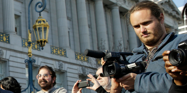 David DePape, right, records the nude wedding of Gypsy Taub outside City Hall on Dec. 19, 2013, in San Francisco. DePape is accused of breaking into House Speaker Nancy Pelosi's California home and severely beating her husband with a hammer. DePape was known in Berkeley, Calif., as a pro-nudity activist who had picketed naked at protests against local ordinances requiring people to be clothed in public.