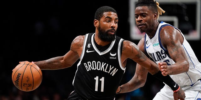 Brooklyn Nets guard Kyrie Irving, #11, drives against Dallas Mavericks forward Reggie Bullock, #25, during the second half of an NBA basketball game, Thursday, Oct. 27, 2022, in New York.