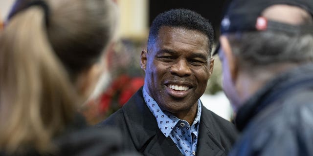 Republican Senate nominee Herschel Walker talks with supporters during a rally on Nov. 21, 2022, in Milton, Georgia. 