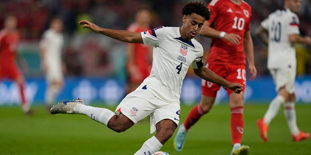 Tyler Adams, of the United States, kick the ball in front of Wales' Aaron Ramsey during the World Cup,Group B soccer match between the United States and Wales, at the Ahmad Bin Ali Stadium in Doha, Qatar, Monday, Nov. 21, 2022.