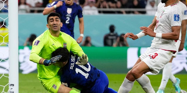 Christian Pulisic, of the United States, center, collides with Iran's goalkeeper Alireza Beiranvand, left, after scoring USA's first goal during the World Cup group B soccer match between Iran and the United States at the Al Thumama Stadium in Doha, Qatar, Tuesday, Nov. 29, 2022. 