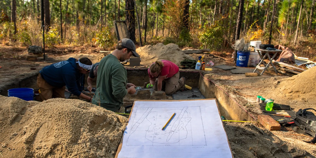 Archeologists cleaning Continental burials at the Battle of Camden site.