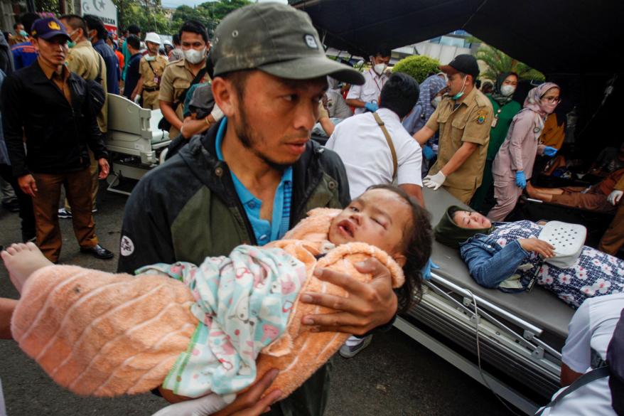 A man carries an injured child to receive treatment at a hospital after an earthquake hit in Cianjur, West Java province, Indonesia, on Nov. 21, 2022.