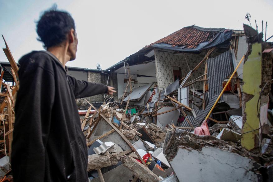 A local stands near houses damaged after the massive earthquake hit in Cianjur, West Java province, Indonesia, on Nov. 21, 2022.