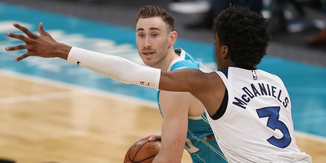 Charlotte Hornets forward Gordon Hayward, left, looks to pass against Minnesota Timberwolves forward Jaden McDaniels during the second half of an NBA basketball game in Charlotte, N.C., Friday, Feb. 12, 2021.