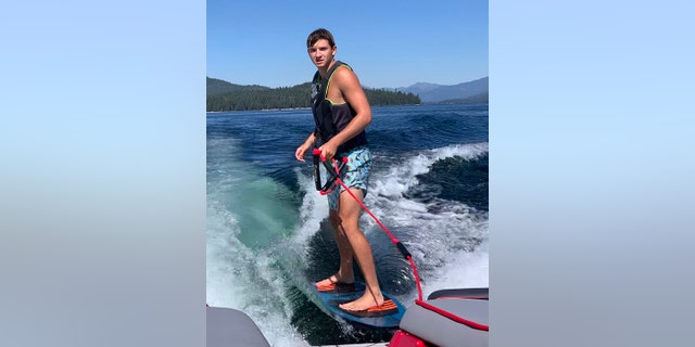 In this photo provided by Stacy Chapin, Ethan Chapin surfs on Priest Lake in northern Idaho in this family snapshot from July 2022. 