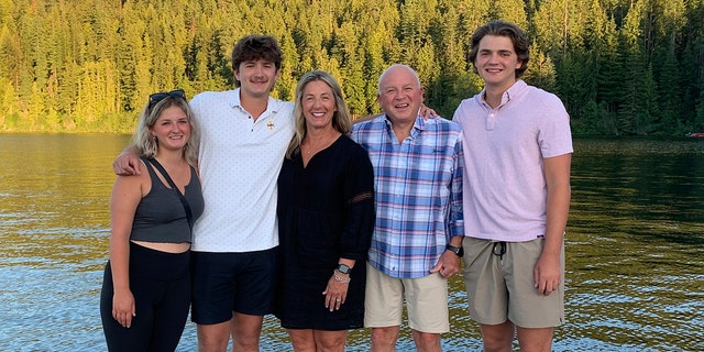 In this photo provided by Stacy Chapin, triplets Maizie, left, Ethan, second from left, and Hunter, right, pose with their parents Stacy and Jim Chapin at Priest Lake in northern Idaho in July 2022. 