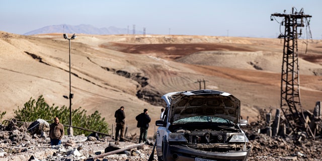 People inspect a site damaged by Turkish airstrikes that hit an electricity station in the village of Taql Baql, in Hasakeh province, Syria, Sunday, Nov. 20, 2022.