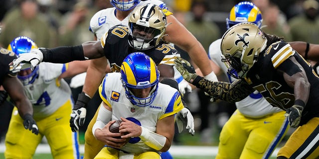 Los Angeles Rams quarterback Matthew Stafford is sacked by New Orleans Saints defenders Tanoh Kpassagnon (90) and Demario Davis (56) in the second half of an NFL football game in New Orleans, Sunday, Nov. 20, 2022. 