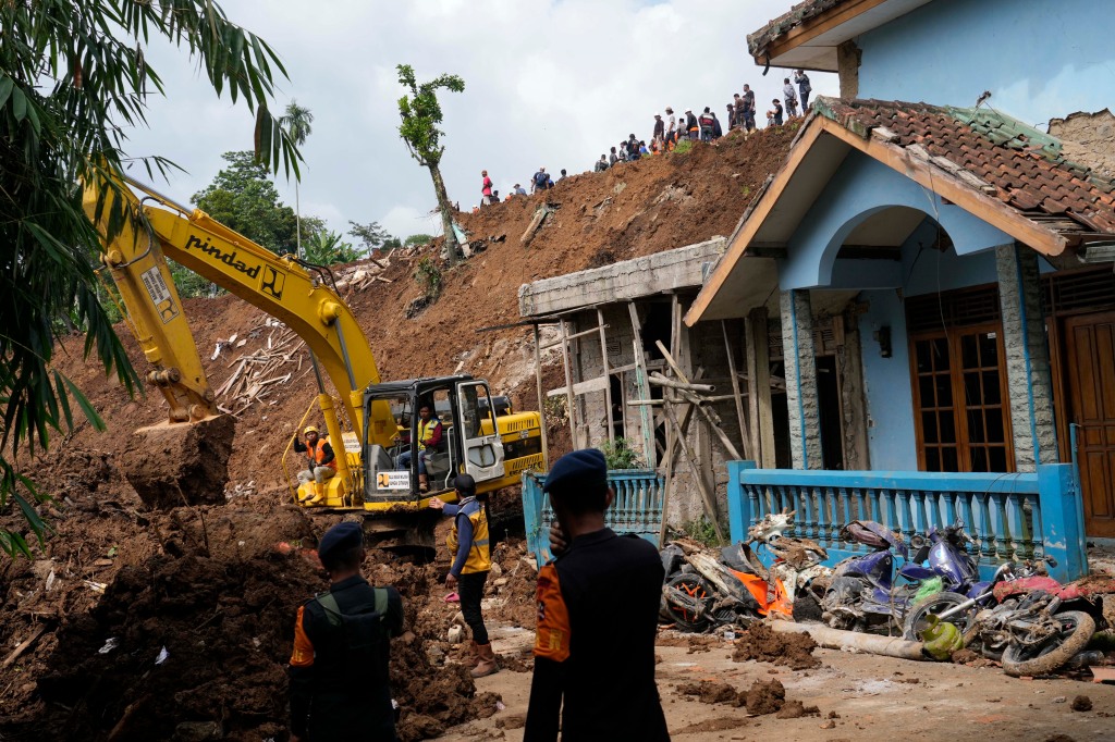 Rescuers use a heavy machine to dig through mud as they search for victims of an earthquake-triggered landslide in Cianjur, West Java, Indonesia, on Nov. 23, 2022. 