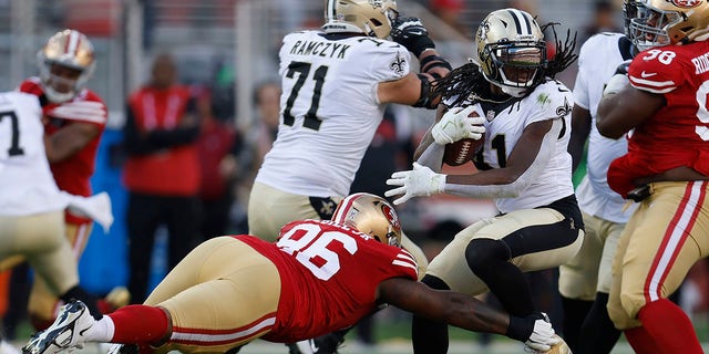 New Orleans Saints running back Alvin Kamara, right, runs against San Francisco 49ers defensive tackle T.Y. McGill, #96, during the first half of an NFL football game in Santa Clara, California, Sunday, Nov. 27, 2022. 