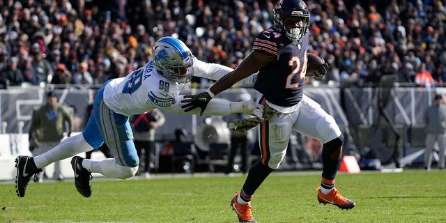 Chicago Bears running back Khalil Herbert (24) runs from Detroit Lions linebacker Julian Okwara (99) during the first half of a game in Chicago Sunday, Nov. 13, 2022.