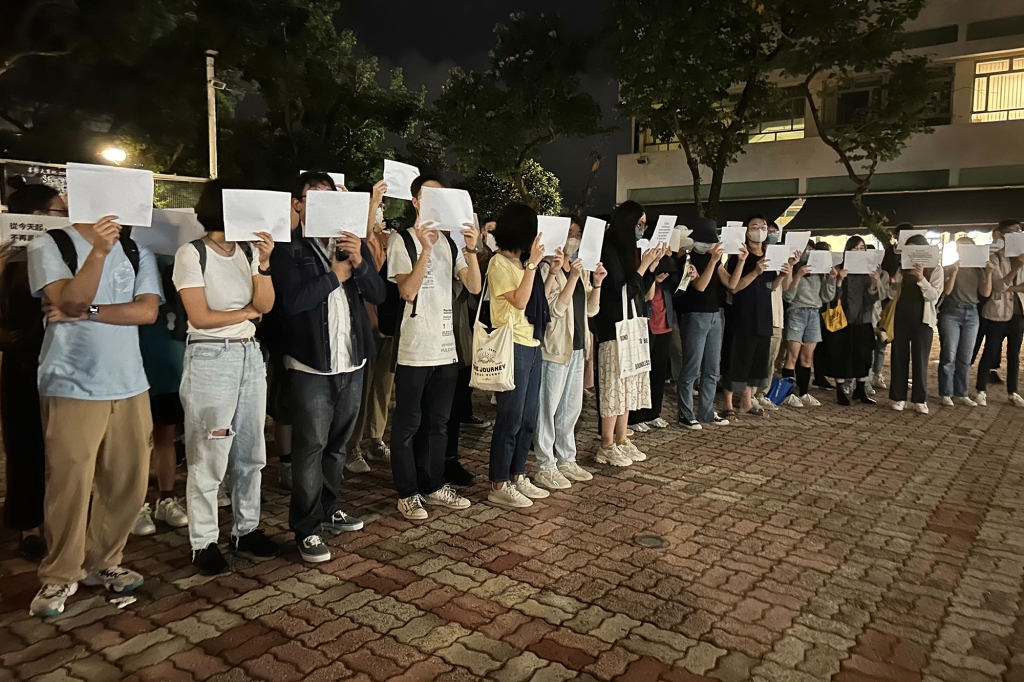 Protesters hold up blank white papers during a commemoration for victims of a recent Urumqi deadly fire at the Chinese University of Hong Kong in Hong Kong, Monday, Nov. 28