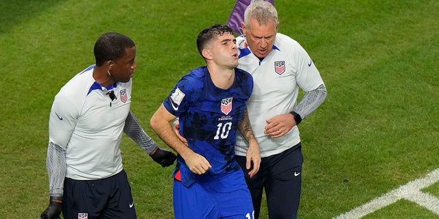 Christian Pulisic, of the United States, is helped by team doctors after he scored USA's opening goal during the World Cup Group B soccer match between Iran and the United States at the Al Thumama Stadium in Doha, Qatar, Tuesday, Nov. 29, 2022. 