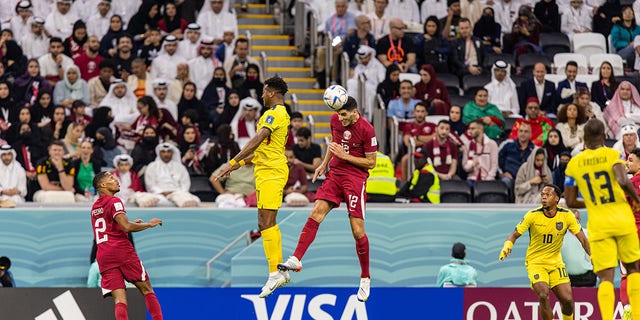 Karim Boudiaf of the Qatar national soccer, center right, heads the ball during the opening match of the FIFA World Cup between host Qatar and Ecuador at Al Bayt Stadium in Al Khor, Qatar, Sunday, Nov. 20, 2022.