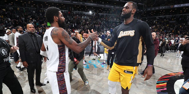 Kyrie Irving, #11 of the Brooklyn Nets, and LeBron James, #23 of the Los Angeles Lakers, high-five after a game on January 23, 2020, at Barclays Center in Brooklyn, New York. 