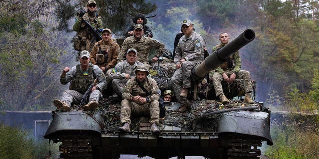 Ukrainian troops ride upon a repaired Russian tank in a wooded area outside the city on Sept. 26, 2022 in Kharkiv, Ukraine. Mechanics are repairing captured Russian tanks that were damaged in battle, so that they can be used by the Ukrainian military against their enemy. 