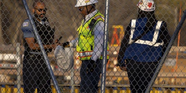 A Chicago police officer, left, takes a bag containing rope from the construction site of the Obama Presidential Center on Thursday, Nov. 10, 2022, in Chicago's Jackson Park neighborhood.