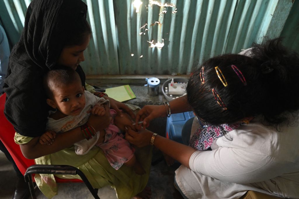 A child is given a vaccine following a measles outbreak in India, on Nov. 23, 2022.