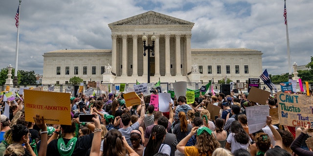 WASHINGTON, DC - JUNE 24: People protest in response to the Dobbs v Jackson Women's Health Organization ruling in front of the U.S. Supreme Court on June 24, 2022 in Washington, DC.