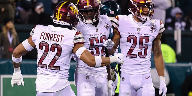 Jamin Davis, #52 of the Washington Commanders, celebrates with Darrick Forrest, #22, and Benjamin St-Juste, #25, after recovering a fumble against the Philadelphia Eagles during the second half at Lincoln Financial Field on November 14, 2022, in Philadelphia, Pennsylvania. 