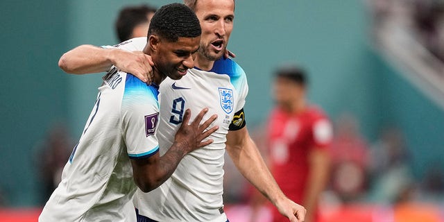 England's Marcus Rashford, left, is congratulated by teammate Harry Kane after scoring his side's fifth goal against Iran during the World Cup in Doha, Qatar, Monday, Nov. 21, 2022.