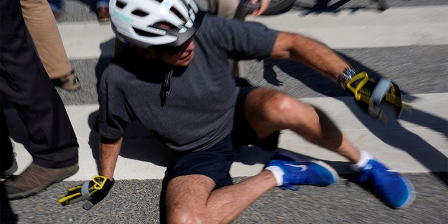 President Biden falls to the ground after riding up to members of the public during a bike ride in Rehoboth Beach, Delaware, June 18, 2022.