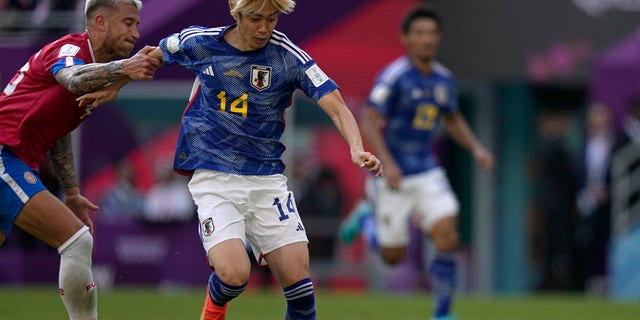 Japan's Junya Ito duels for the ball with Costa Rica's Francisco Calvo during the World Cup, group E match in Al Rayyan , Qatar, Sunday, Nov. 27, 2022.