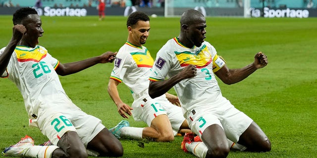 Senegal's Kalidou Koulibaly, right, celebrates with teammates during the World Cup match against Ecuador at the Khalifa International Stadium in Doha, Qatar, Tuesday, Nov. 29, 2022.