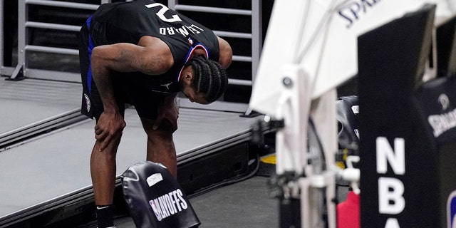 Los Angeles Clippers forward Kawhi Leonard holds his knee after stepping awkwardly during the second half in Game 4 of a second-round NBA basketball playoff series against the Utah Jazz Monday, June 14, 2021, in Los Angeles. (AP Photo/Mark J. Terrill)