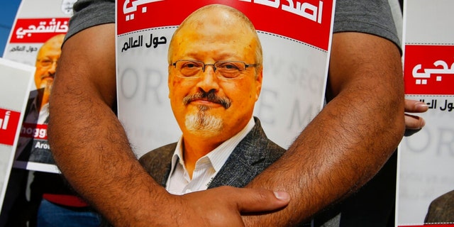 People hold posters of slain Saudi journalist Jamal Khashoggi, near the Saudi Arabia consulate in Istanbul, Oct. 2, 2020, marking the two-year anniversary of his death. 