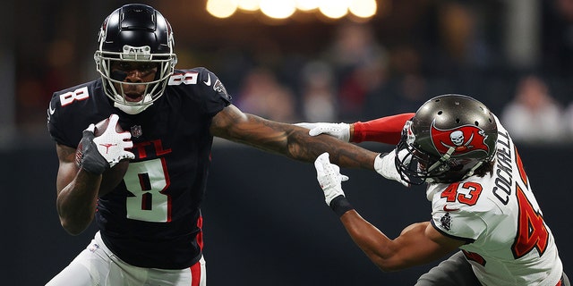 Kyle Pitts #8 of the Atlanta Falcons carries the ball after a reception as Ross Cockrell #43 of the Tampa Bay Buccaneers defends during the second quarter at Mercedes-Benz Stadium on December 05, 2021 in Atlanta, Georgia.